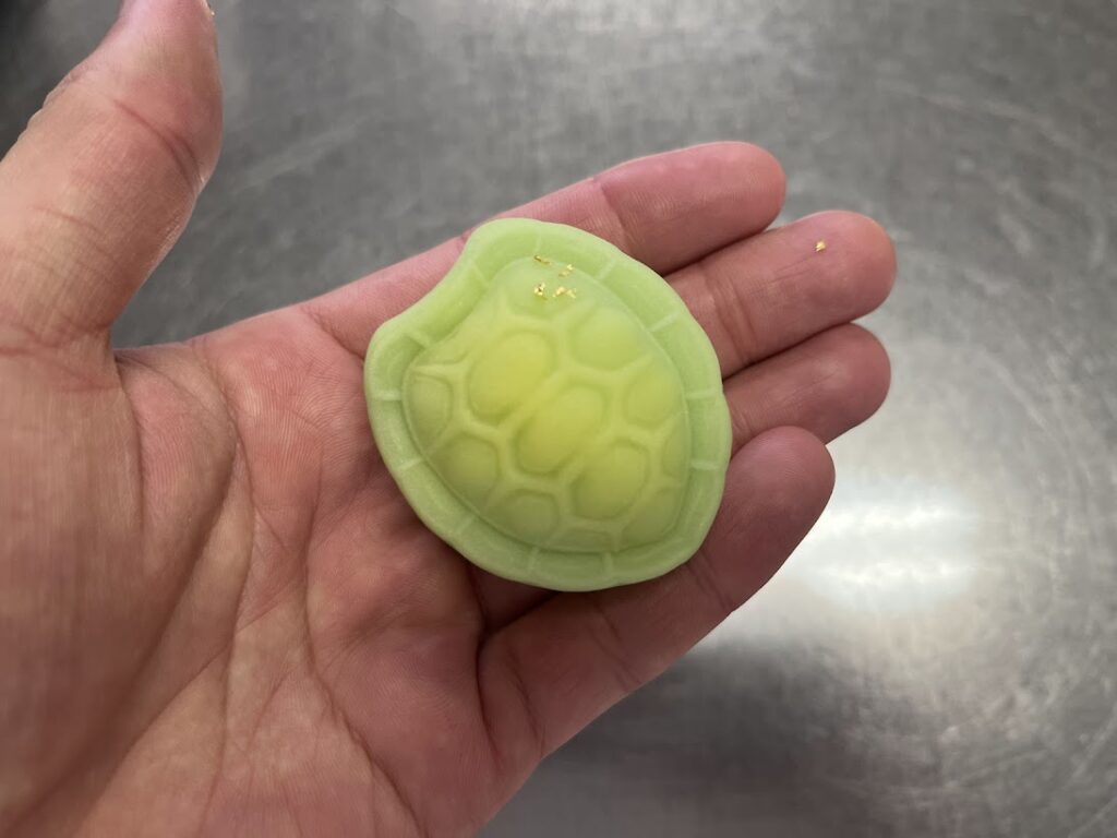 木型から抜いた上生菓子の亀に金粉を乗せる